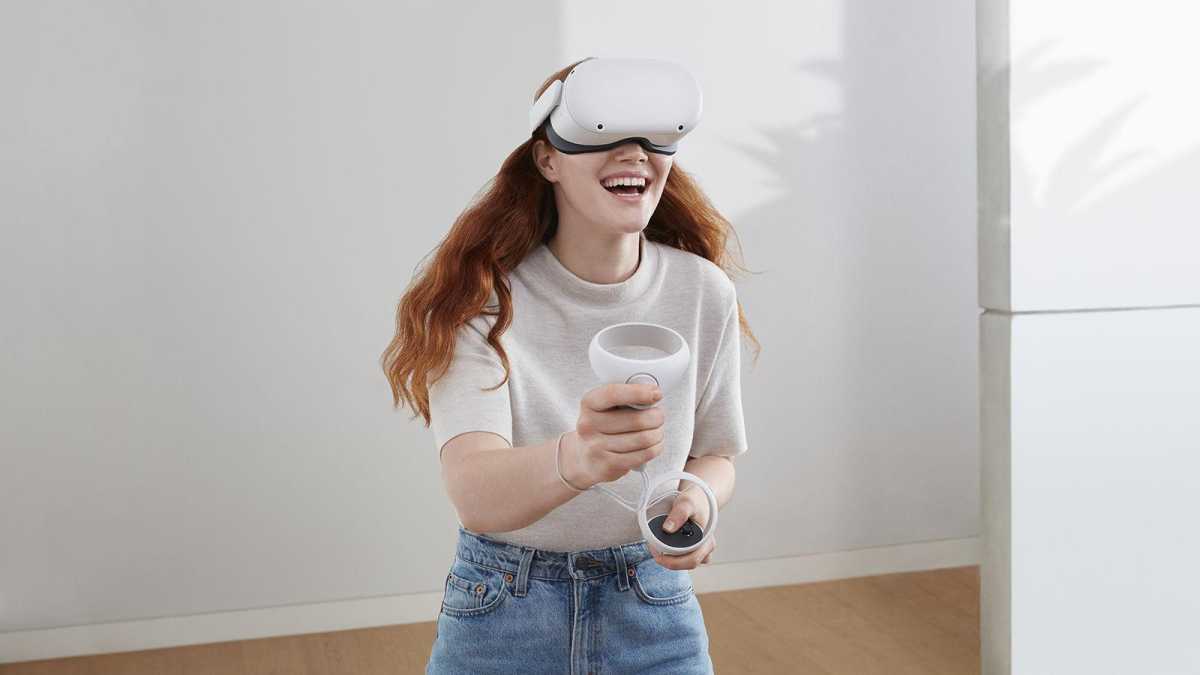 Una mujer que usa Oculus Quest 2, sonriendo en una habitación sencilla