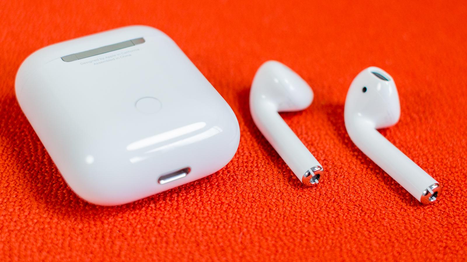 AirPods en una superficie naranja