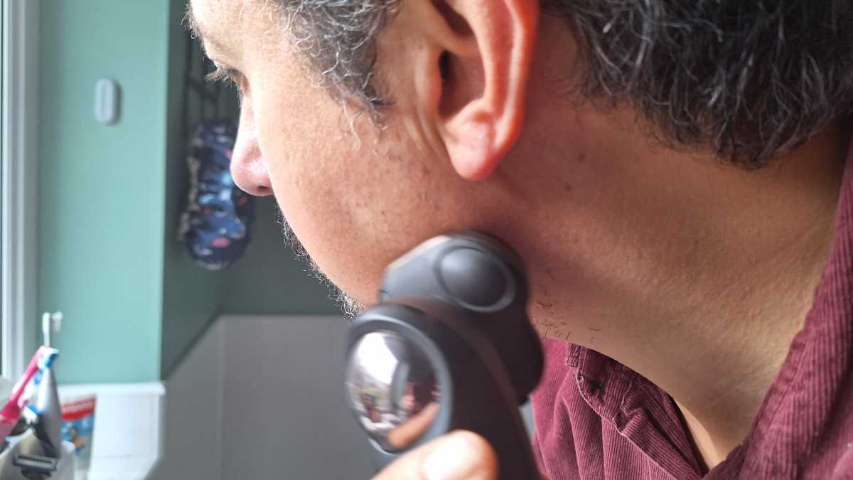 A close up view of a man using the Remington Limitless X9 rotary shaver 