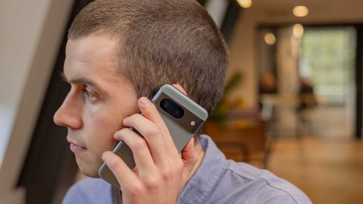 Un hombre sosteniendo un teléfono inteligente en su oreja