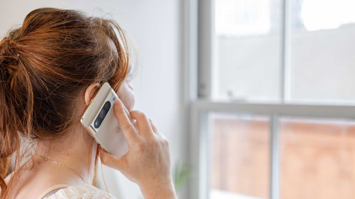 Una mujer sosteniendo el Google Pixel 8 Pro cerca de su oreja