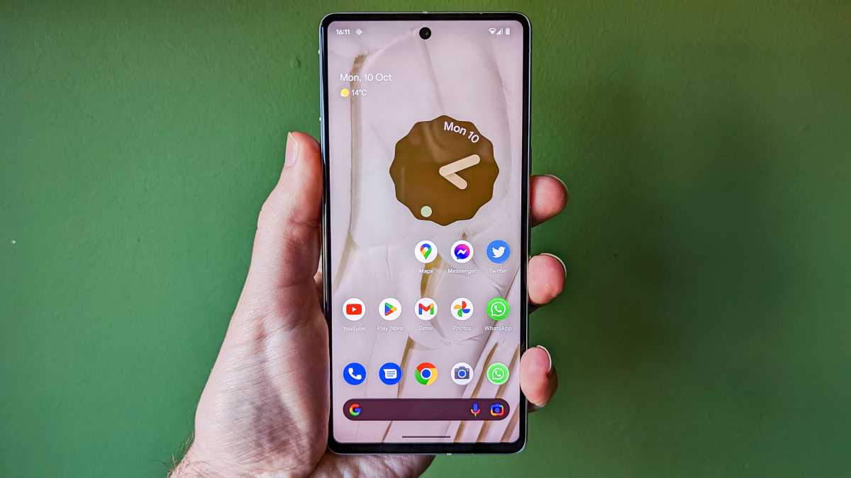 Pantalla de Google Pixel 7 en la pared verde en la mano